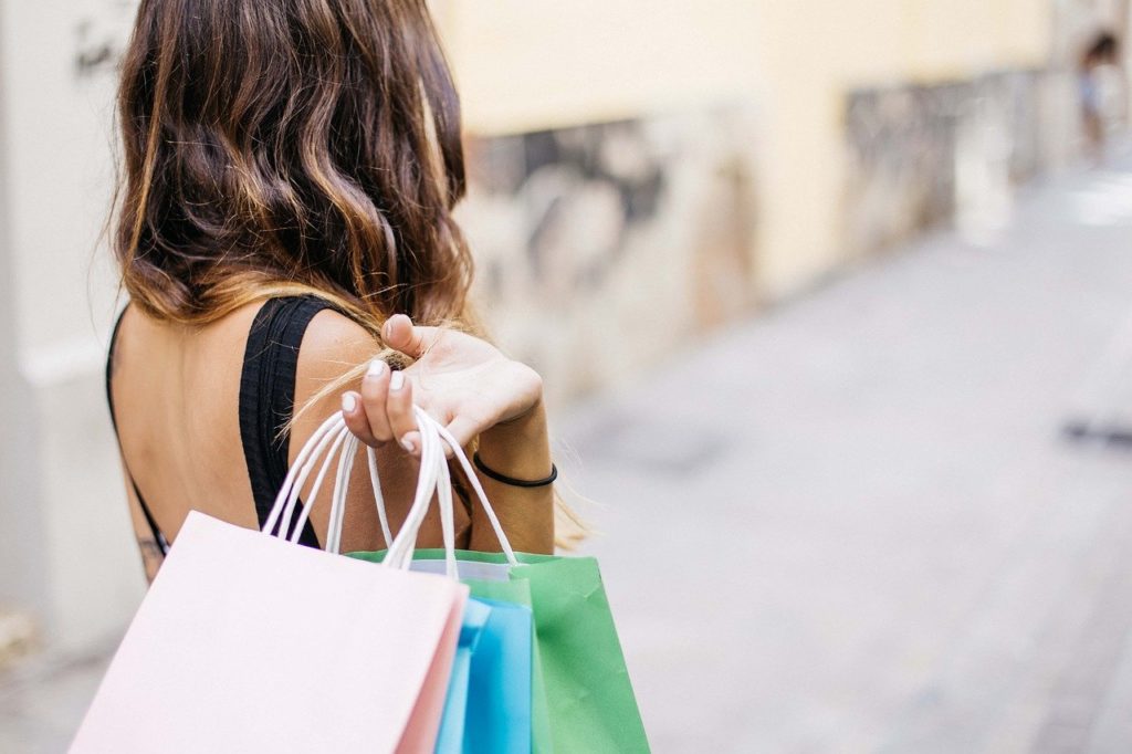 Frau hält Taschen Mehrfarbig einkaufen Konsum shoppen Shopping