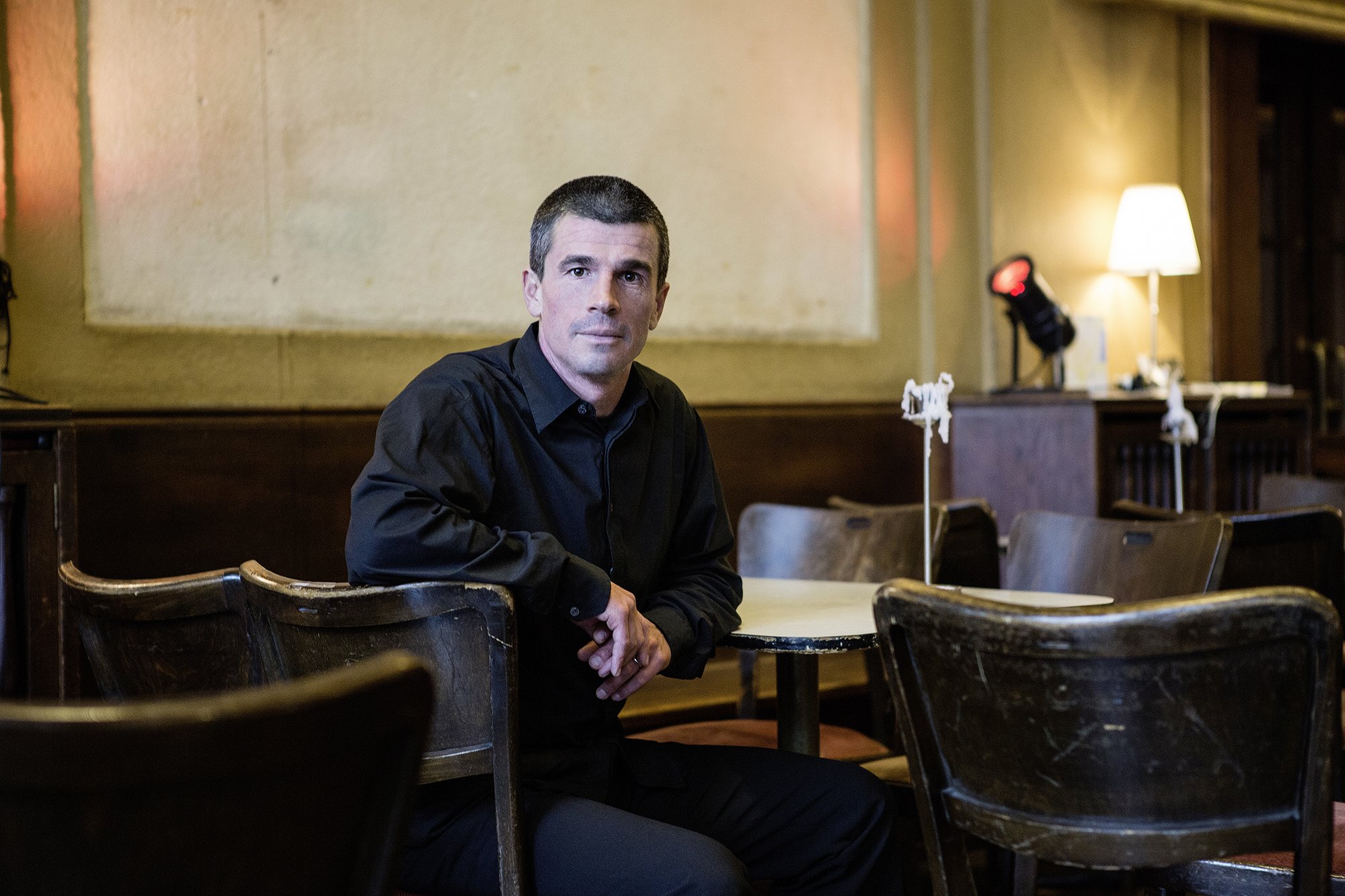 Portrait Mann sitzen Hintergrund Kulturzentrum