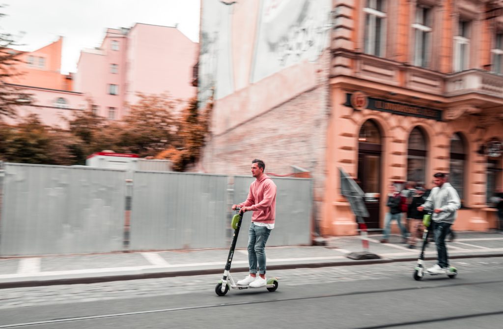 Person E-Trottinett fahren urban Stadt rosa pink schnell