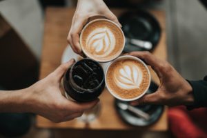 Kaffee anstossen kalt warm drei Personen Hände