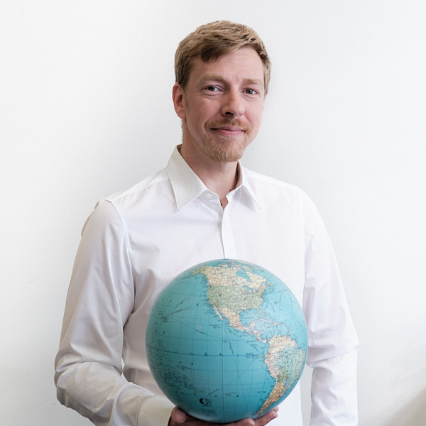 Team MYBLUEPLANET Max Rüttinger hält Planet weisser Hintergrund