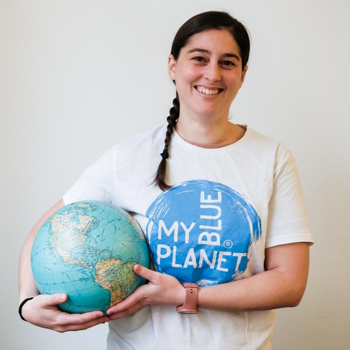 Team MYBLUEPLANET Annamarie Dober hält Planet fröhlich lachen weisser Hintergrund
