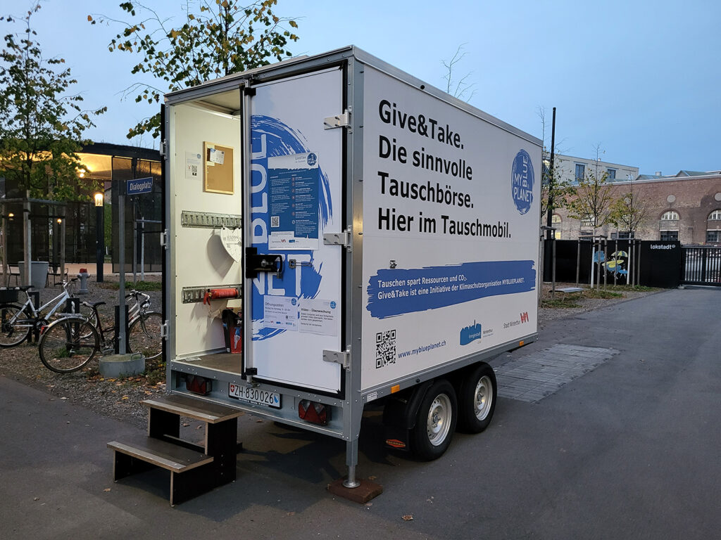 Give and Take Tauschmobil Anhänger Dialogplatz im Park blau